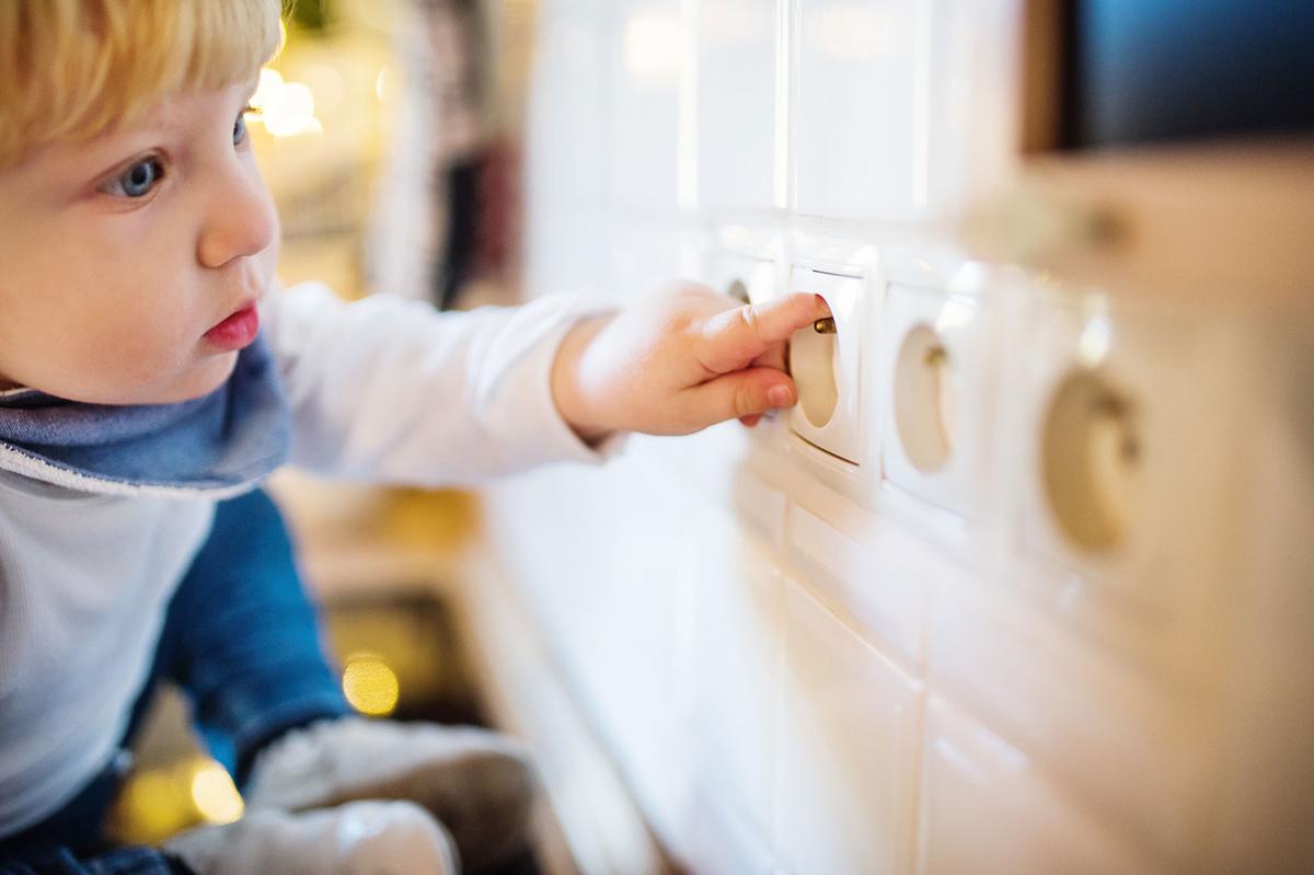 Öffnet eine Lightbox: Ein kleines Kind versucht seinen Finger in eine Steckdose zu stecken.