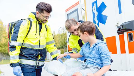 Ein leicht verletzter Junge wird vor einem Einsatzwagen von einem Notarztteam betreut